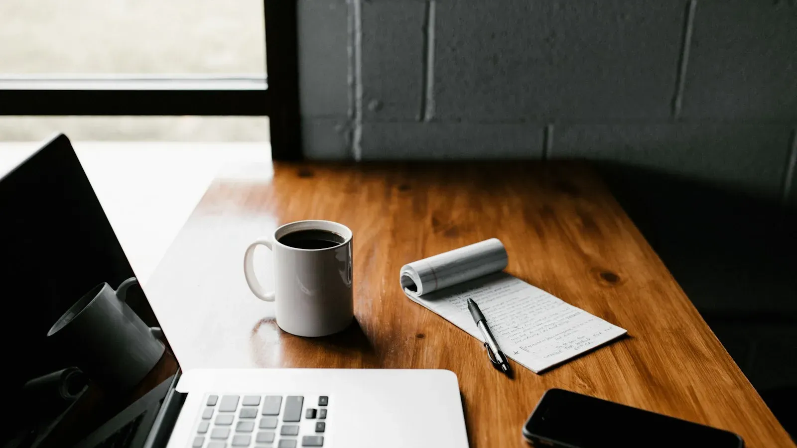 Espace de travail avec ordinateur et carnet, invitation à faire une vraie pause