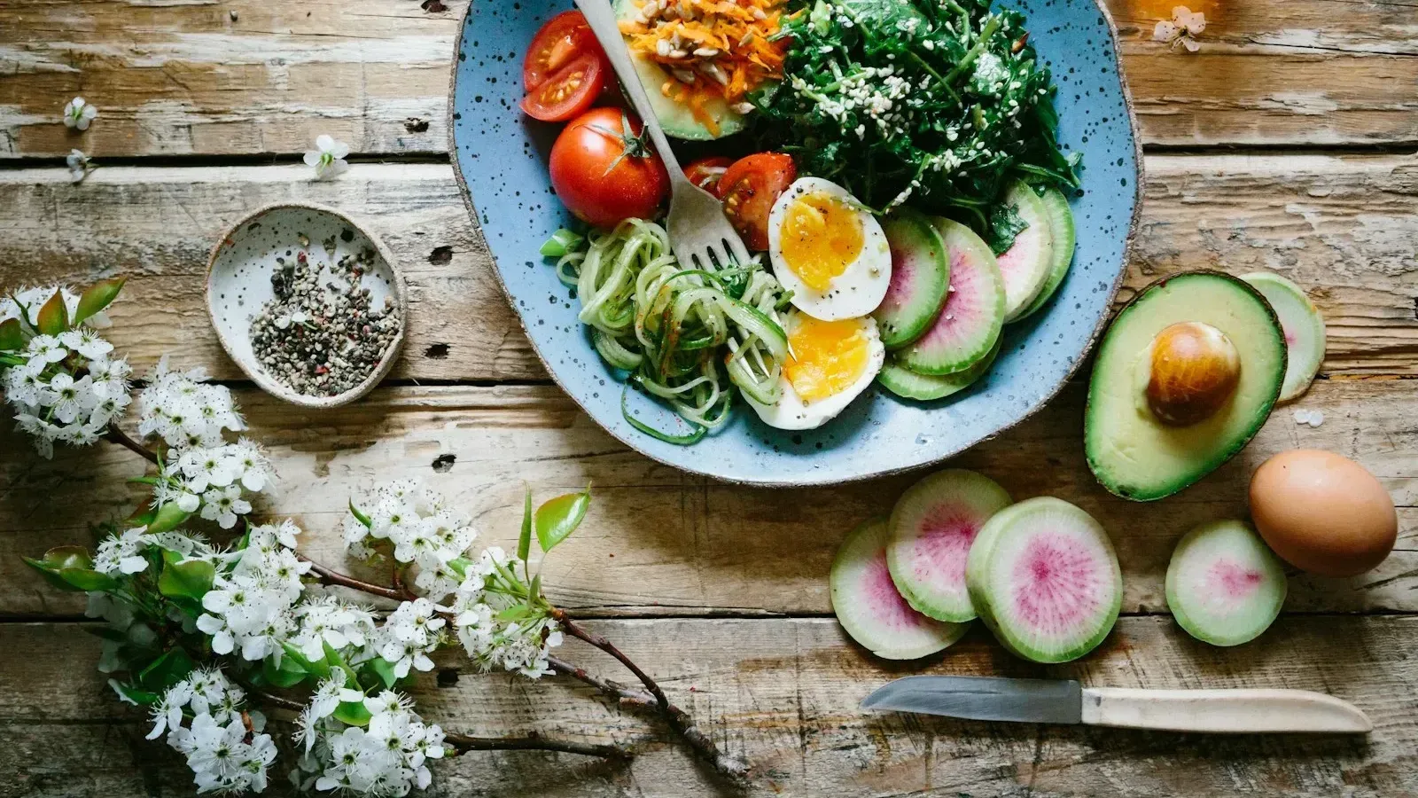 Assiette colorée avec œufs, avocat, légumes et graines, illustration d’un repas varié apportant des protéines